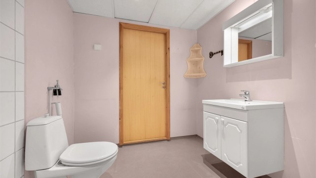 Badet har gulvbelegg og mekanisk avtrekk via ventil i himlingen.