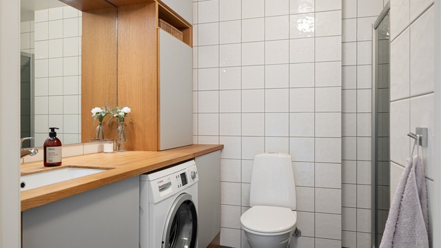 Flislagt baderom med gode oppbevaringsløsninger.