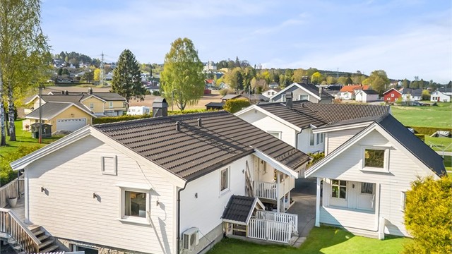 Tilnærmet flat tomt som er opparbeidet med singlet innkjørsel og grøntarealer, herunder gressplen samt hekk.