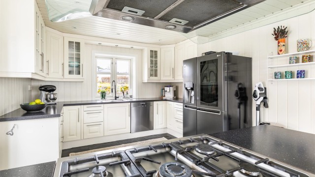 Kjøkkenet er meget praktisk å benytte i hverdagen. Arbeidsflatene er store og oppbevaringsmulighetene mange.