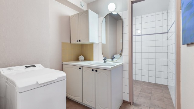 Bad fra 1997 med flislagt gulv, flislagte og tapetserte vegger samt malt himling. Badet er tredelt, og har eget toalettrom og rom til dusj.
