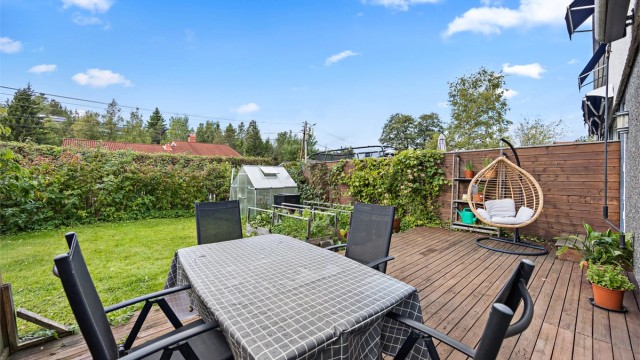 Terrassen har god plass til spisebord og leder ut i den grønne hagen.