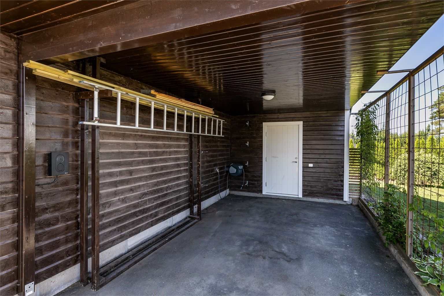 Lader til El-bil er montert i carporten. Boden innerst i carporten er på ca. 5 kvm.