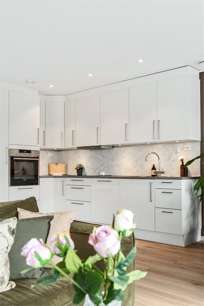 Kjøkkeninnredning fra HTH (2016) med glatte fronter og integrerte hvitevarer som stekeovn, platetopp og oppvaskmaskin.