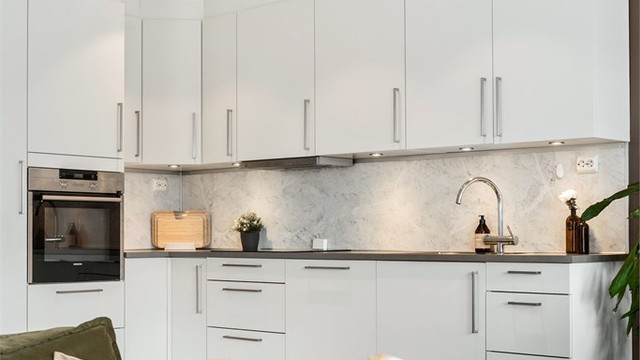 Kjøkkeninnredning fra HTH (2016) med glatte fronter og integrerte hvitevarer som stekeovn, platetopp og oppvaskmaskin.