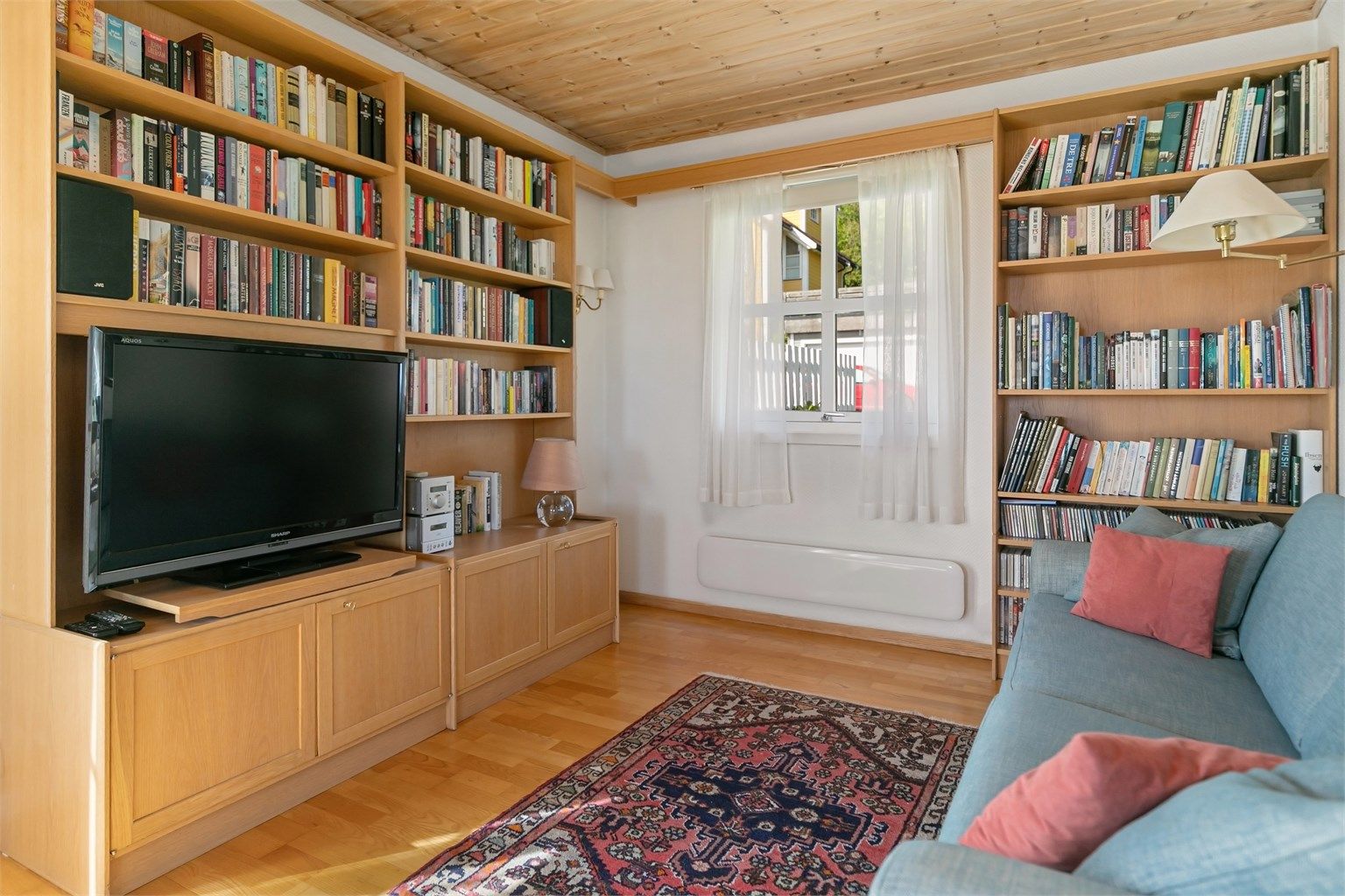 En del av stuen er innredet som bibliotek med plassbygde bokhyller.