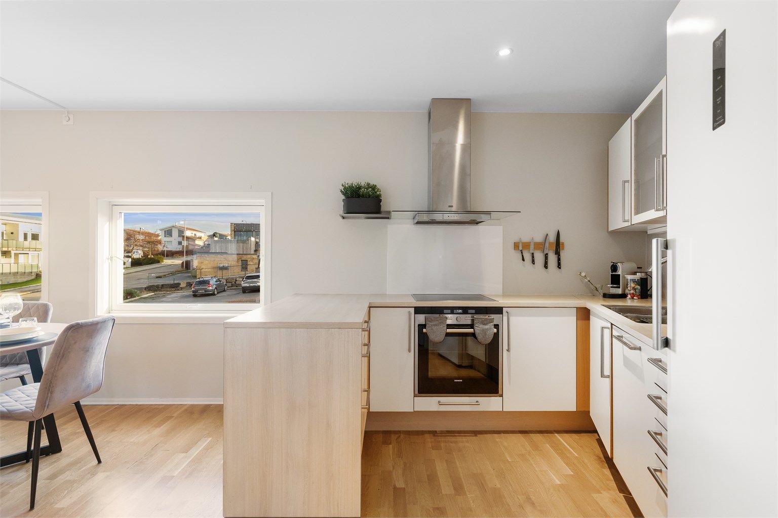 Bak kjøkkenet finner du en romslig kjøkkenbod som gir ekstra lagringsplass og oversiktlig organisering.