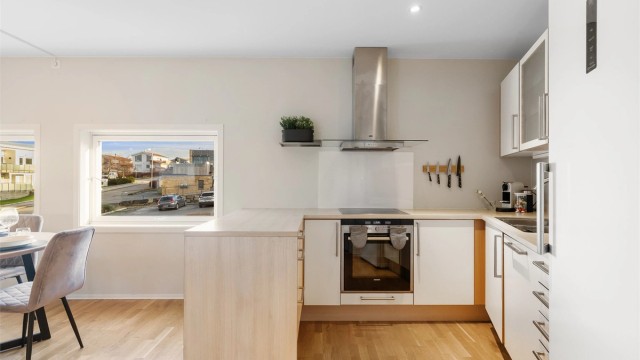 Bak kjøkkenet finner du en romslig kjøkkenbod som gir ekstra lagringsplass og oversiktlig organisering.