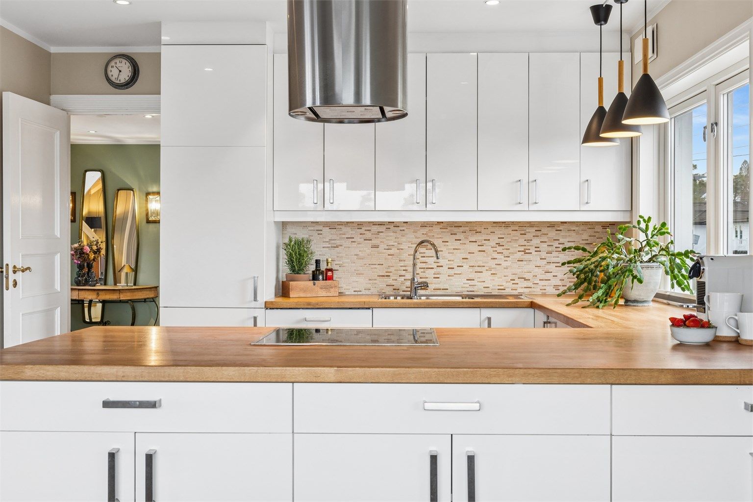 Kjøkkeninnredning fra 2011 med glatte fronter, heltre benkeplate og integrerte hvitevarer som medfølger.