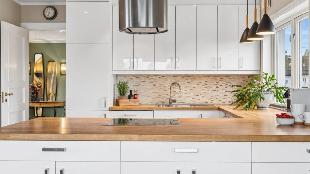 Kjøkkeninnredning fra 2011 med glatte fronter, heltre benkeplate og integrerte hvitevarer som medfølger.