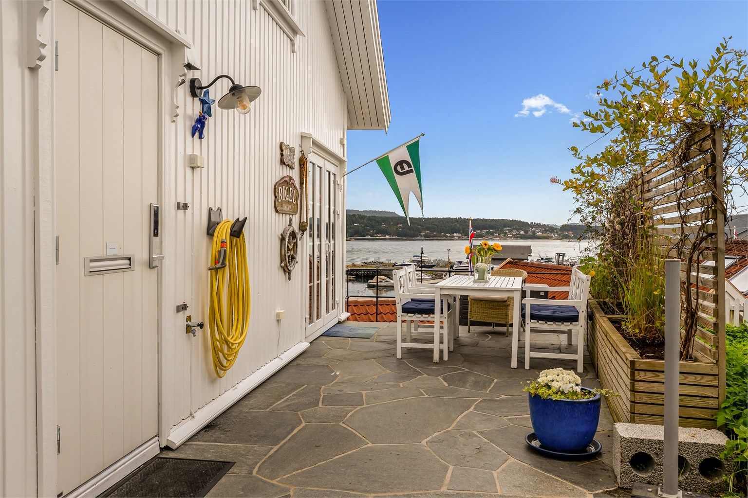 Lettstelt med skifer lagt terrasse. Leveggen mot syd har integrerte blomster kasser.
