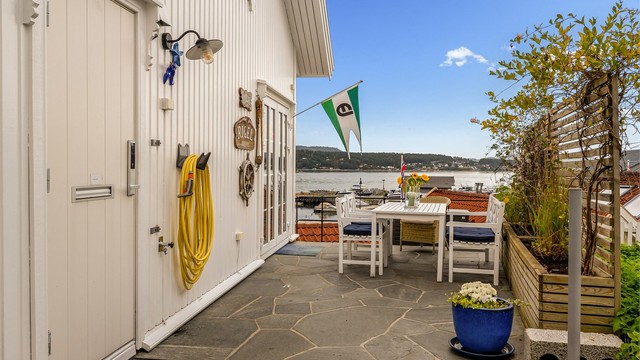 Lettstelt med skifer lagt terrasse. Leveggen mot syd har integrerte blomster kasser.