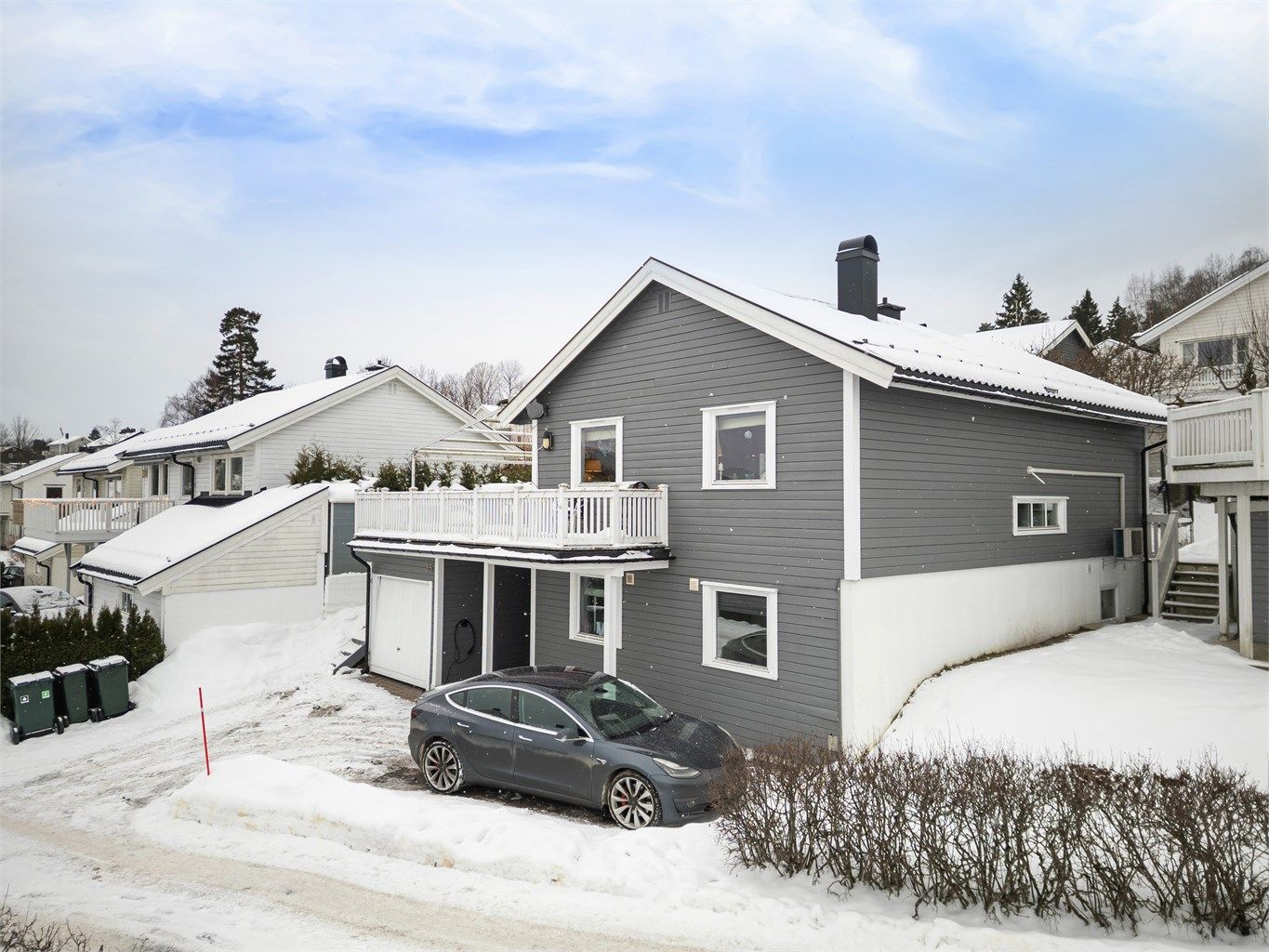 Parkering i integrert garasje med el-billader og disponibel gårdsplass.