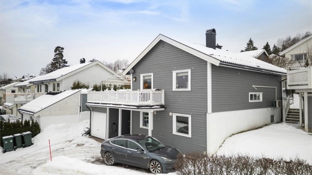 Parkering i integrert garasje med el-billader og disponibel gårdsplass.