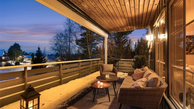 Fra stuen er det utgang til en terrasse med utsikt mot borettslagets grønne fellesområde.
