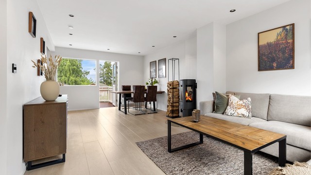 Romslig stue med downlights i taket og god plass til møblering med både spisestue og sofagruppe