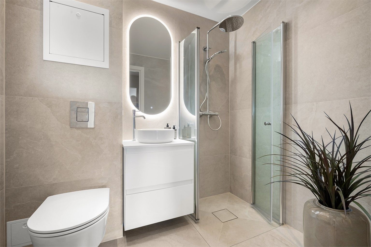 Stilrent bad, rehabilitert i 2026, med delikate fliser, regndusj og speil med belysning.