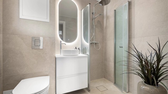 Stilrent bad, rehabilitert i 2026, med delikate fliser, regndusj og speil med belysning.