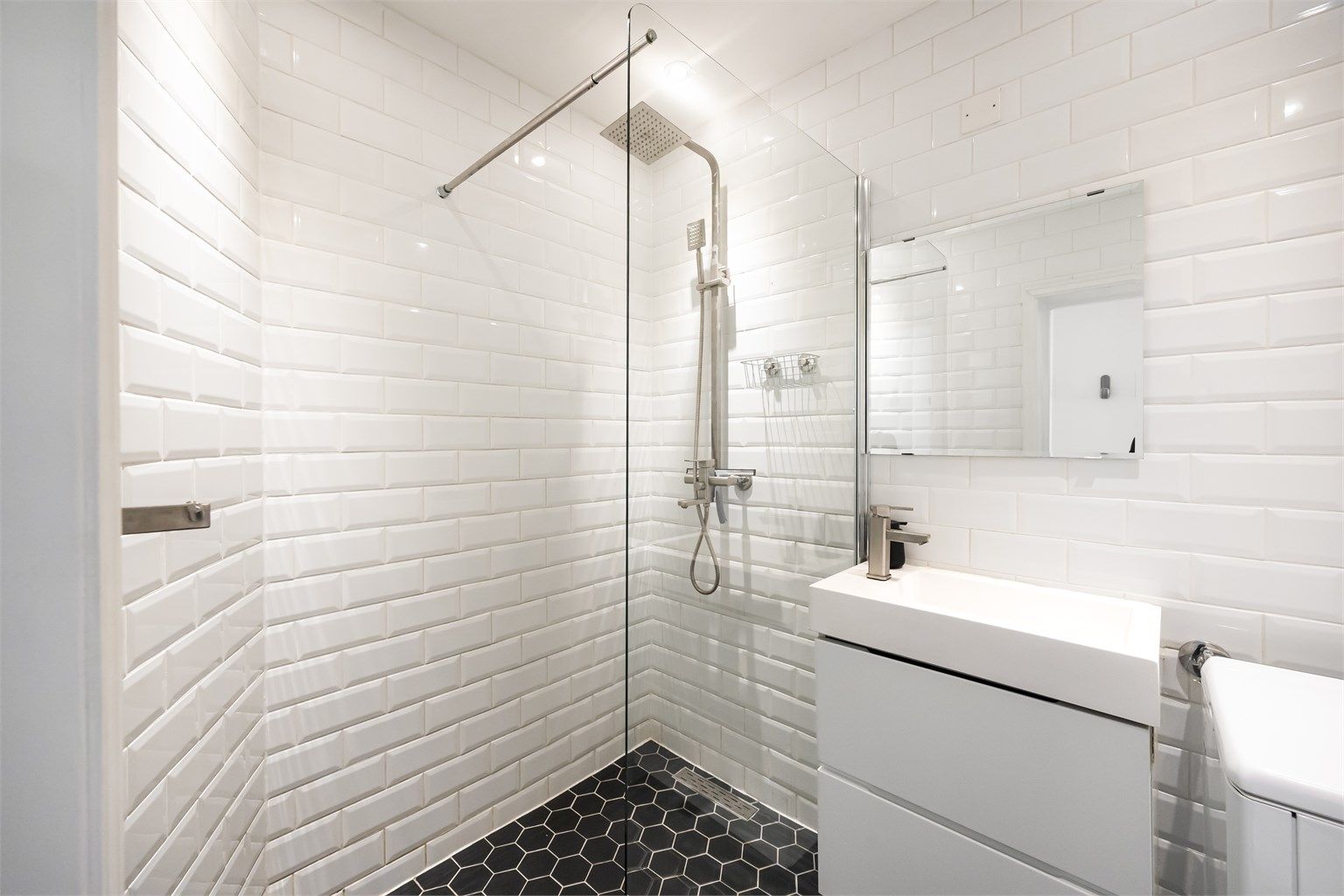 Videre er det vegghengt toalett og dusjnisje med glassvegg som er tilkoblet både hånd- og regndusj. Det er opplegg for vaskemaskin på badet.