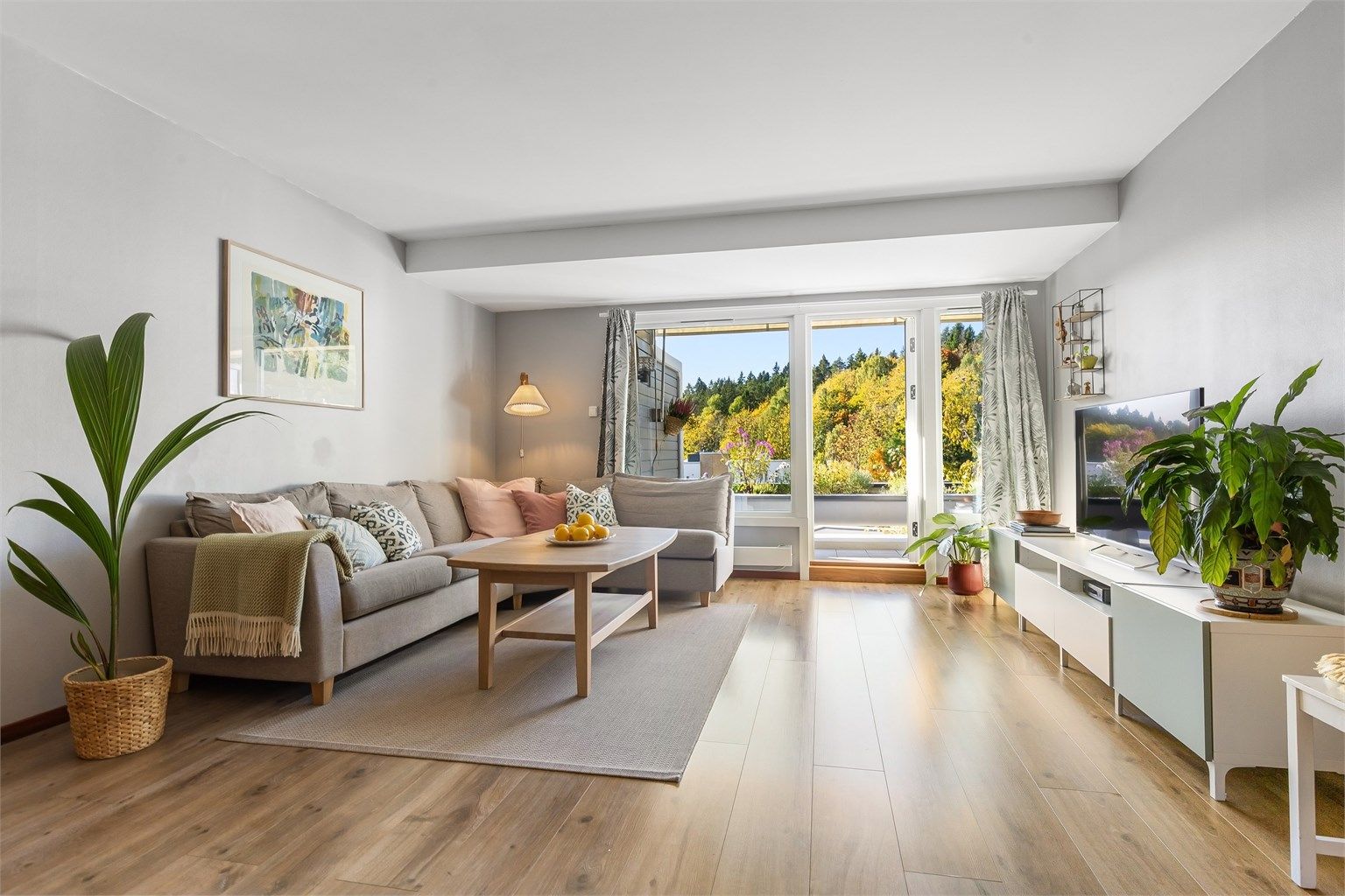 Stuen har god plass til stor sofagruppe og store vindusflater mot naturen utenfor.