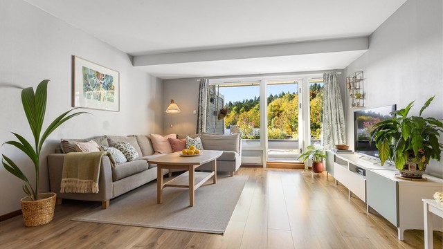 Stuen har god plass til stor sofagruppe og store vindusflater mot naturen utenfor.
