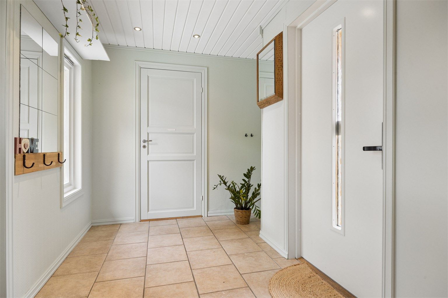 Entré med flislagt gulv med varme og downlights i himlingen. Plass til skoskap og knaggrekke.