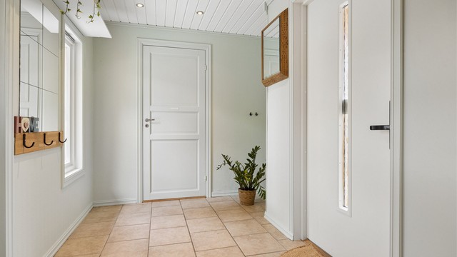 Entré med flislagt gulv med varme og downlights i himlingen. Plass til skoskap og knaggrekke.