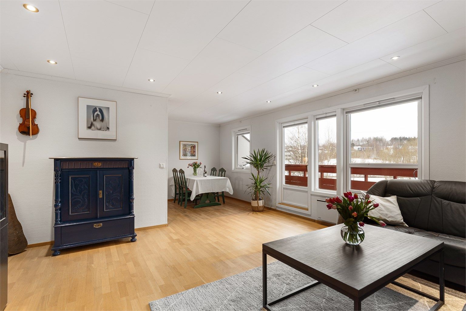 Stuen har store vindusflater som gir godt med naturlig lys. Vinduene og balkongdøren i stuen ble byttet i 2022