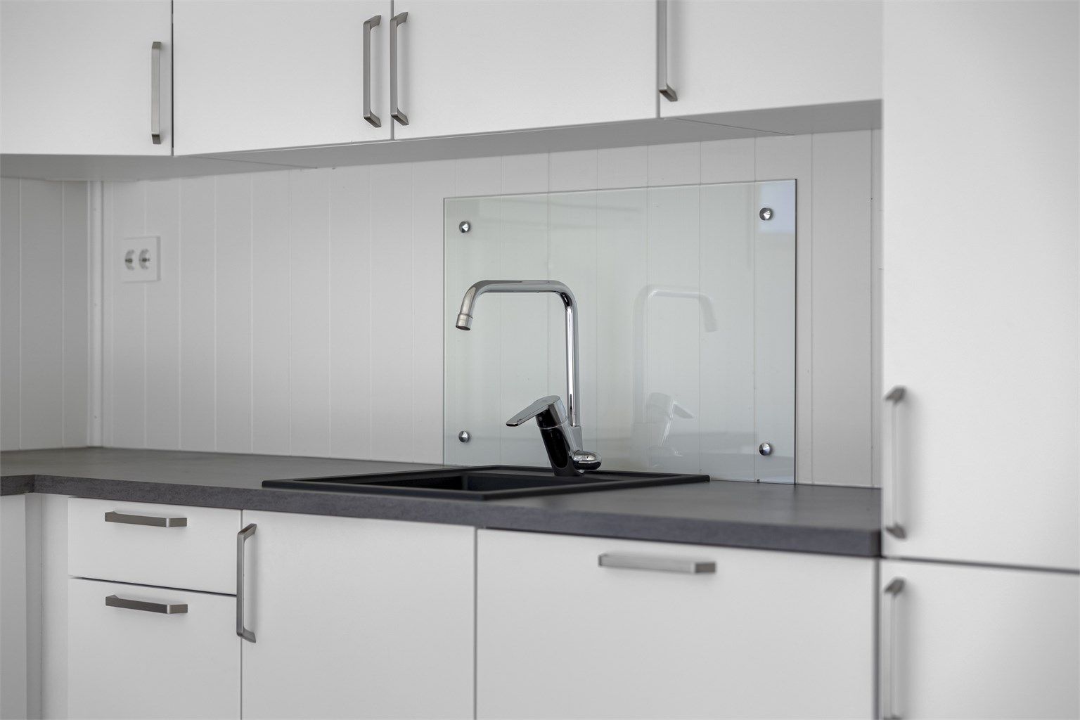 Benkeplate i laminat og nedfelt servant. Kjøkkenventilator med kullfilter.