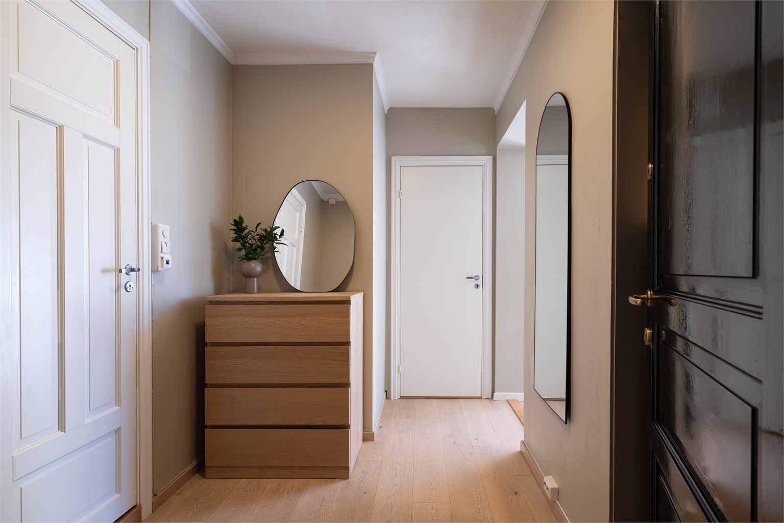 Praktisk og romslig entré med plass til kommode og oppheng av ytterklær i nisje. 