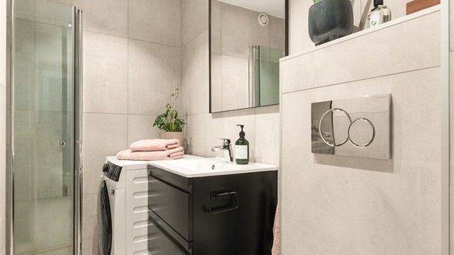 Badet er utstyrt med gulvvarme, vegghengt toalett, servantinnredning og opplegg for vaskemaskin.