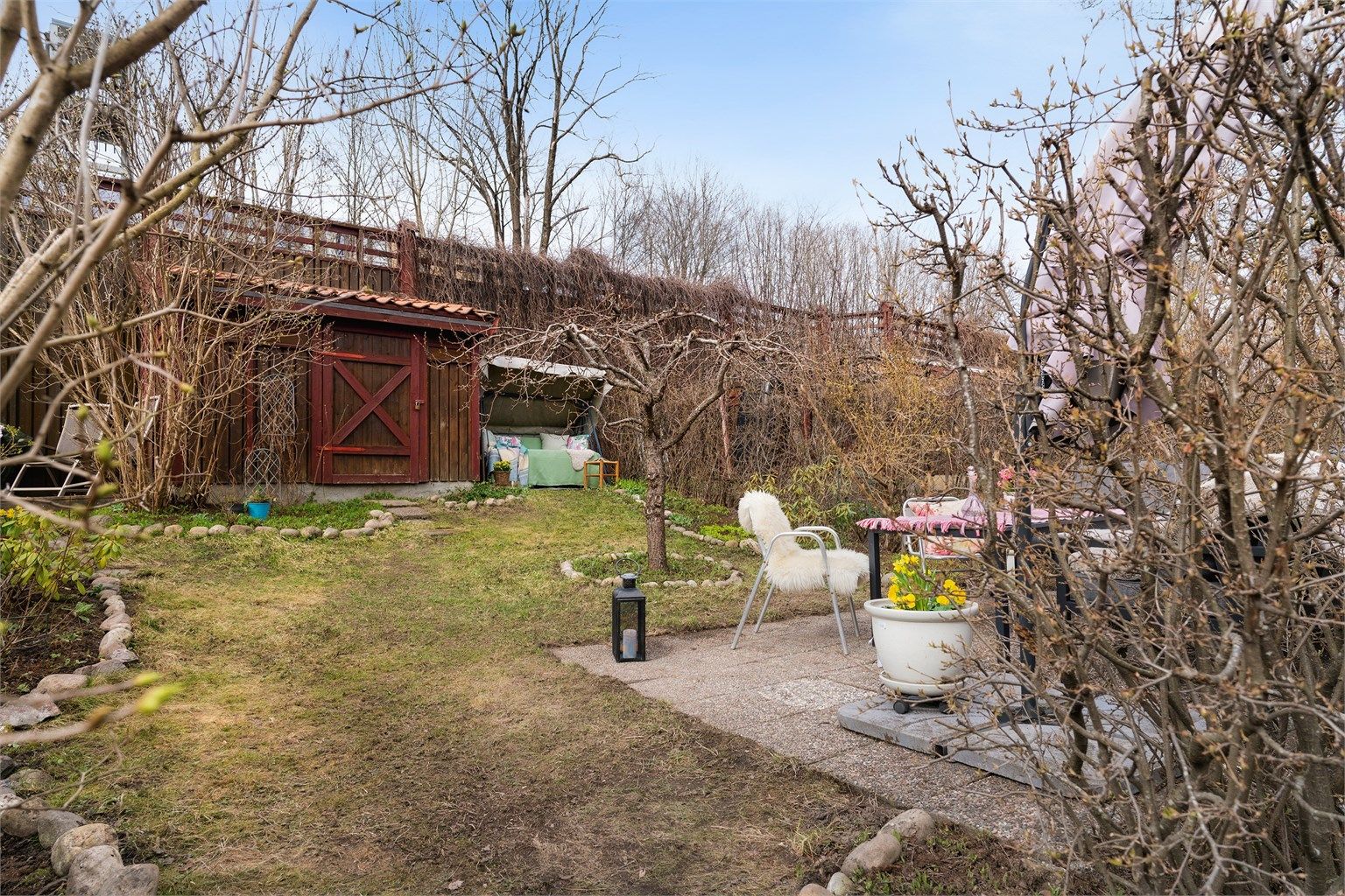 I hagen står en praktisk utebod på ca. 5 m² for oppbevaring av hageredskaper og utemøbler.