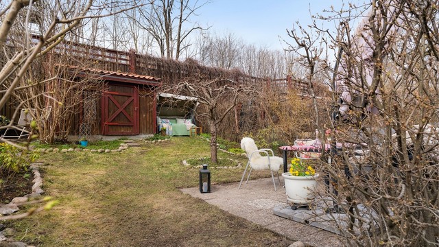 I hagen står en praktisk utebod på ca. 5 m² for oppbevaring av hageredskaper og utemøbler.