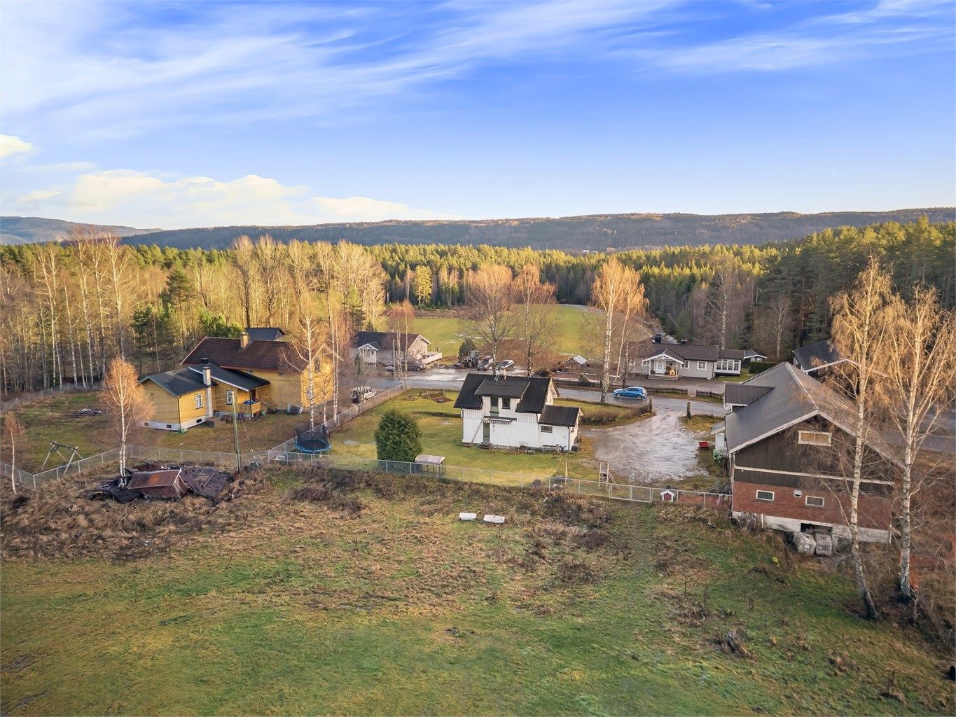God plass til parkering på gårdsplassen mellom eneboligen og låven. Inngjerdet hage. Totalt ca 19 mål tomt.