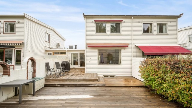 Uteplass belagt med terrassebord og skjermende hekk. Foto: Martine Eren Jacobsen