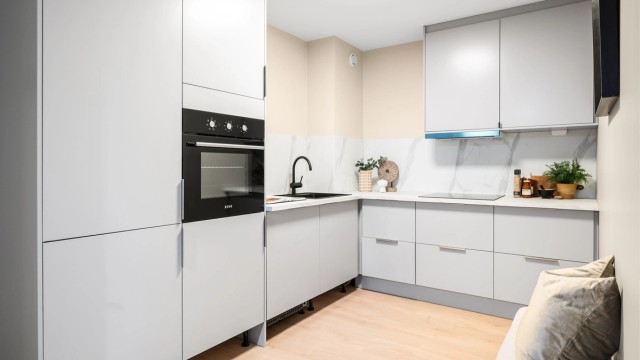 Kjøkkenet er nytt i 2025 med moderne innredning fra Norema med glatte fronter, laminat benkeplate med nedfelt vaskekum, overskap og sprutplater over benkeplaten. List under skap monteres fortløpende.