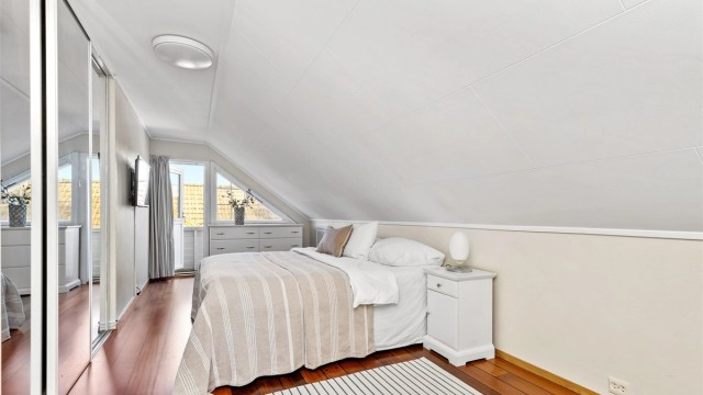 Hovedsoverommet i andre etasje har god takhøyde, skyvedørsgarderobe med speil og direkte utgang til egen balkong.