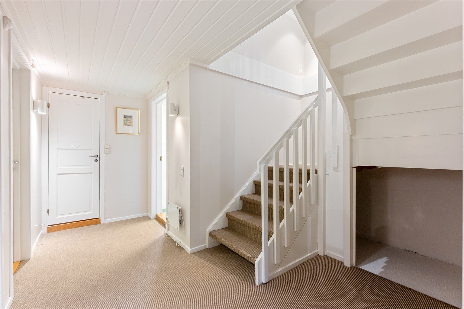 Trappegang i kjelleren med sisalteppe og adkomst til etasjens øvrige rom.