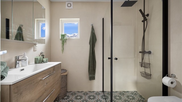 Delikat, flislagt baderom med varme i gulv og downlights i himling