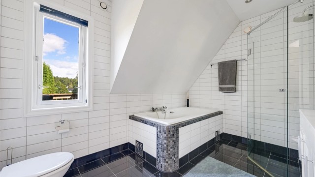 Lyst og romslig bad med flislagt gulv og vegger. Det er varmekabler i gulv med ny gulvtermostat og spotter i taket.