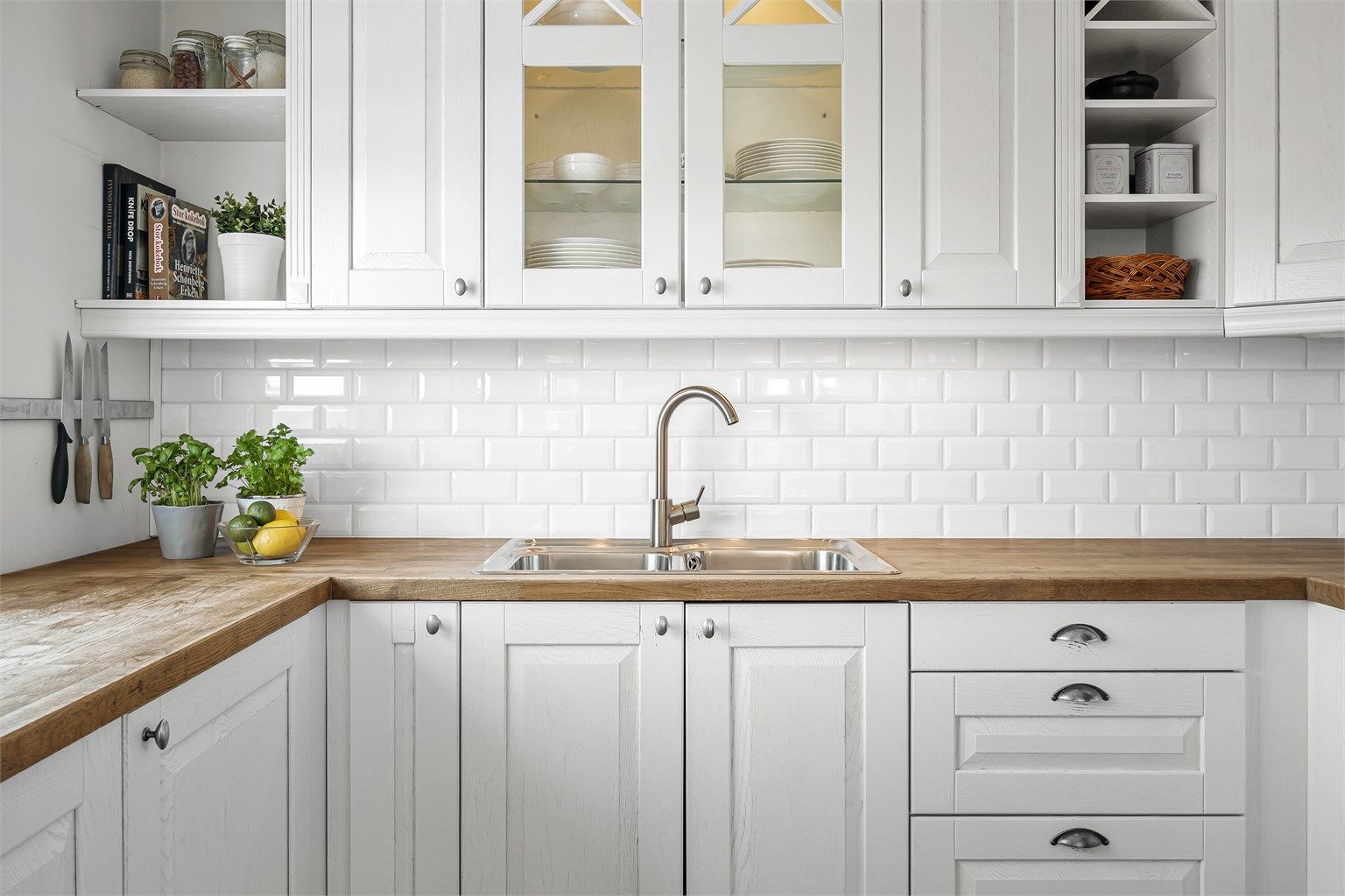 Praktisk nedfelt dobbel oppvaskkum og fliser på veggen mellom benk og overskap.