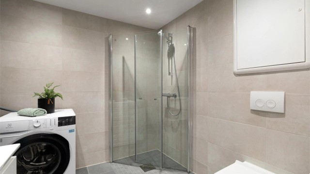 Praktiske svingbare dusjdører i herdet glass. Det er vannbåren gulvvarme på badet og varmt forbruksvann er inkludert i felleskostnadene (a-konto)