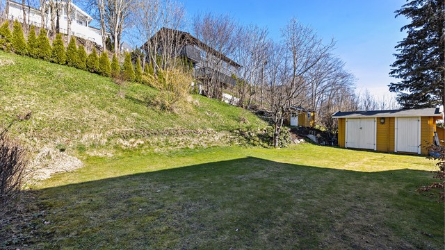 Boligen har en hyggelig hage med diverse beplantning og utvendig bod.