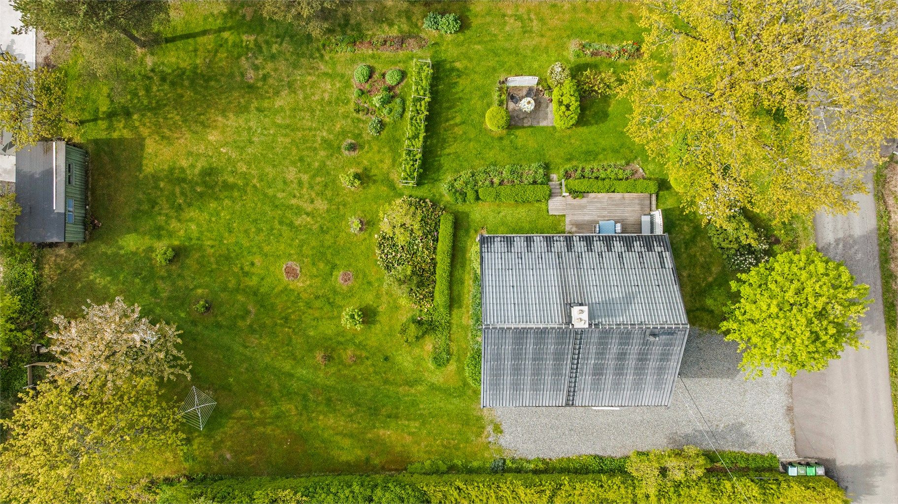 Tomten er opparbeidet med plen, hekker og diverse beplantning, samt en frittstående bod.