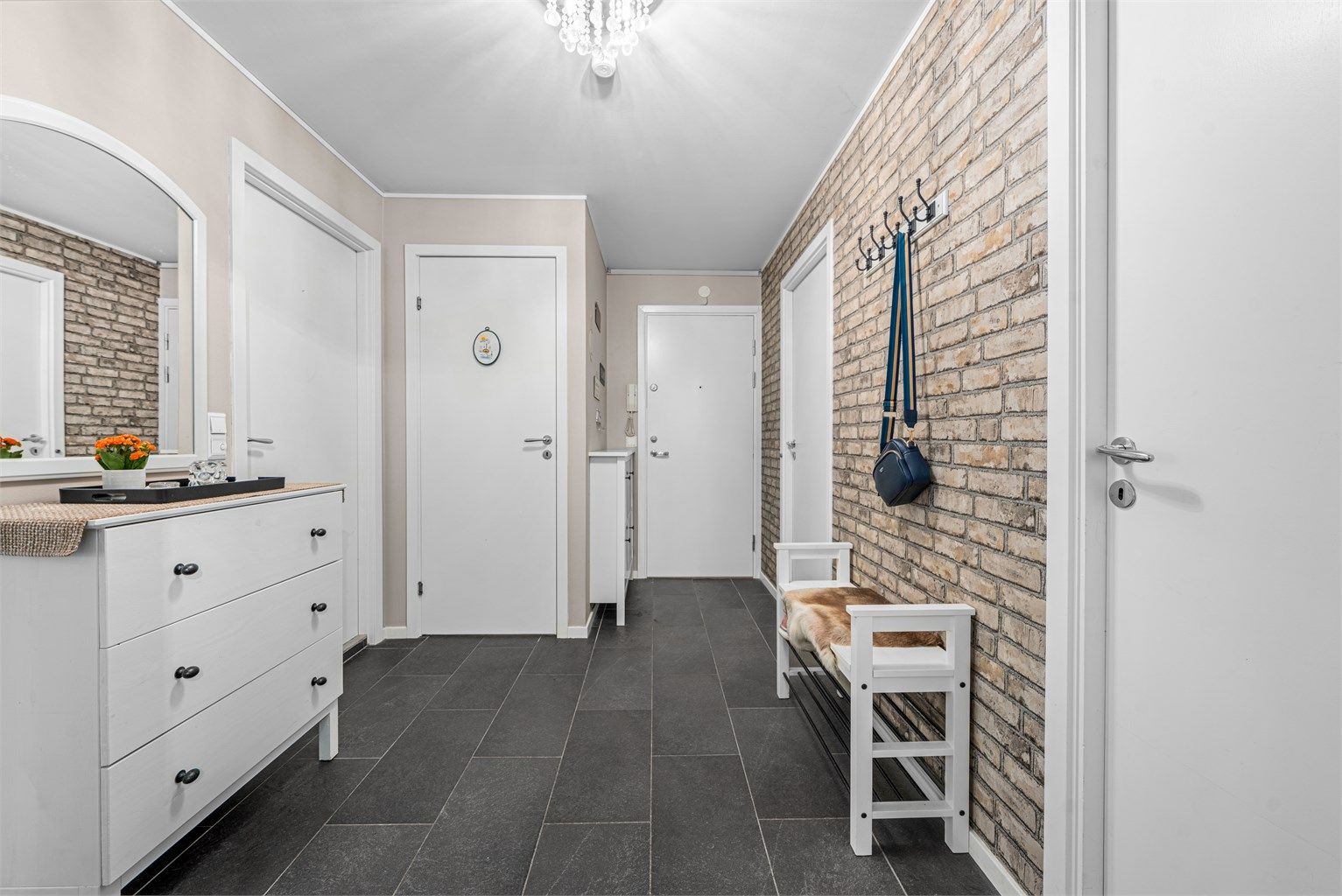 Leiligheten har en innbydende entré med fin plass til å henge fra seg yttertøy og sette fra seg sko. 