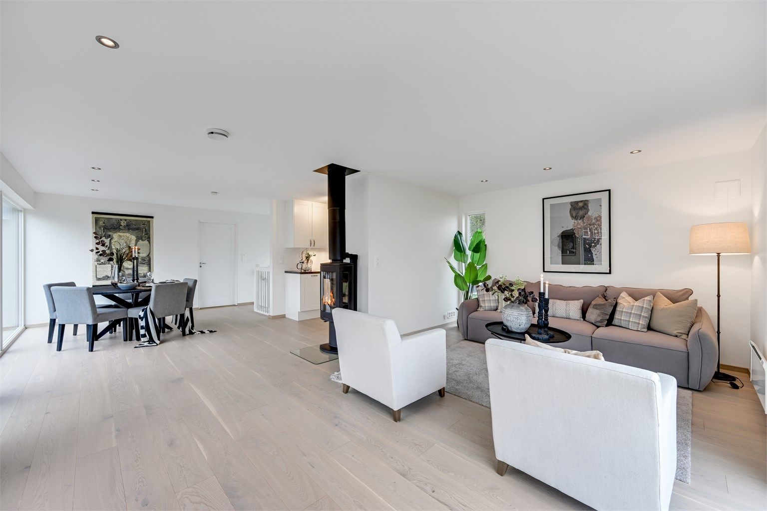 Stuen i andre etasje er et lyst og luftig samlingspunkt med gjennomgående parkett og en lun vedovn.