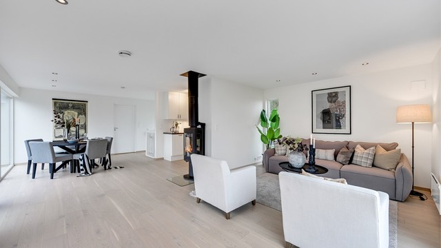 Stuen i andre etasje er et lyst og luftig samlingspunkt med gjennomgående parkett og en lun vedovn.