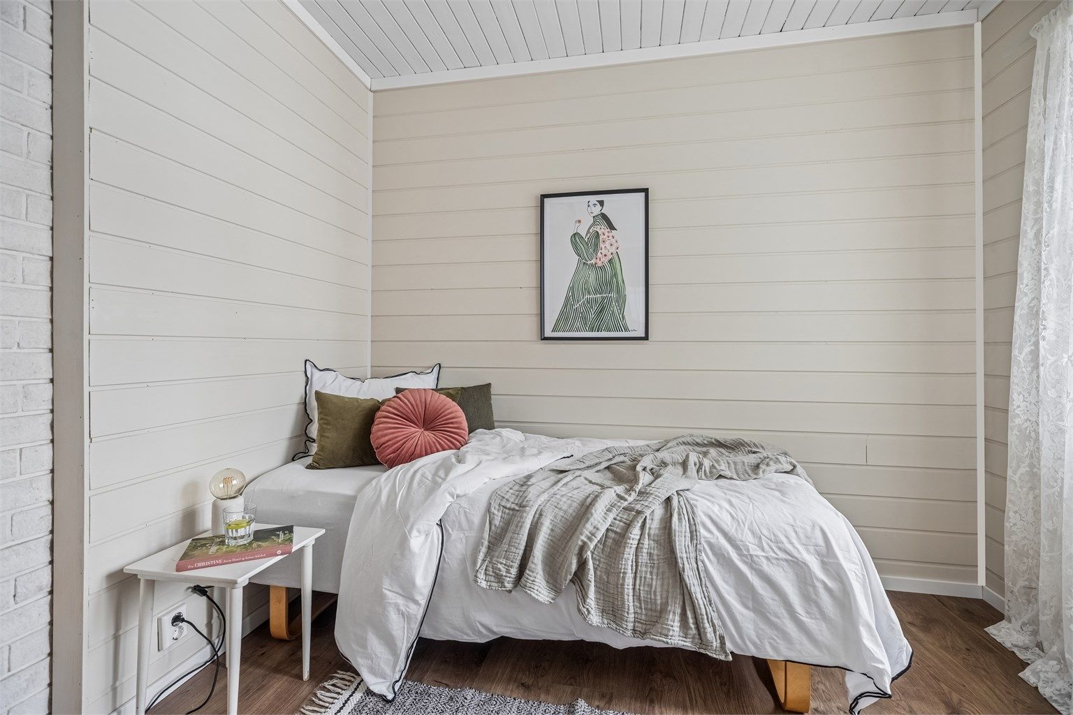 Et hyggelig rom med malt panel på vegger og i himling.