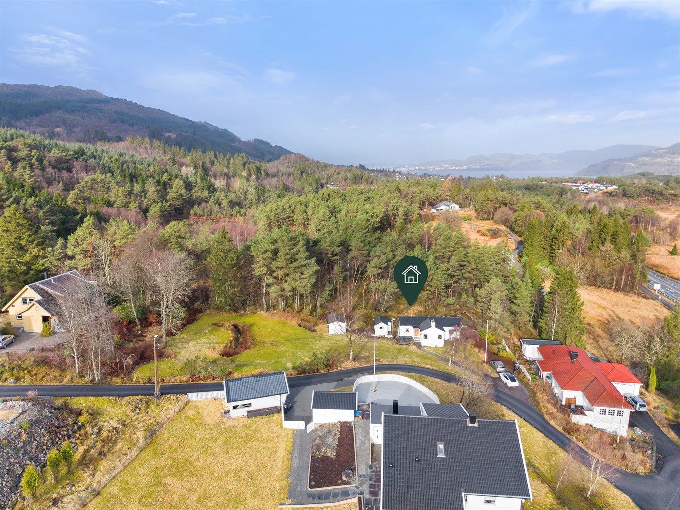 Tomten er opparbeidet med blant annet asfalterte vei, grus, biloppstillingsplass, plenarealer og andre forskjellige beplantninger