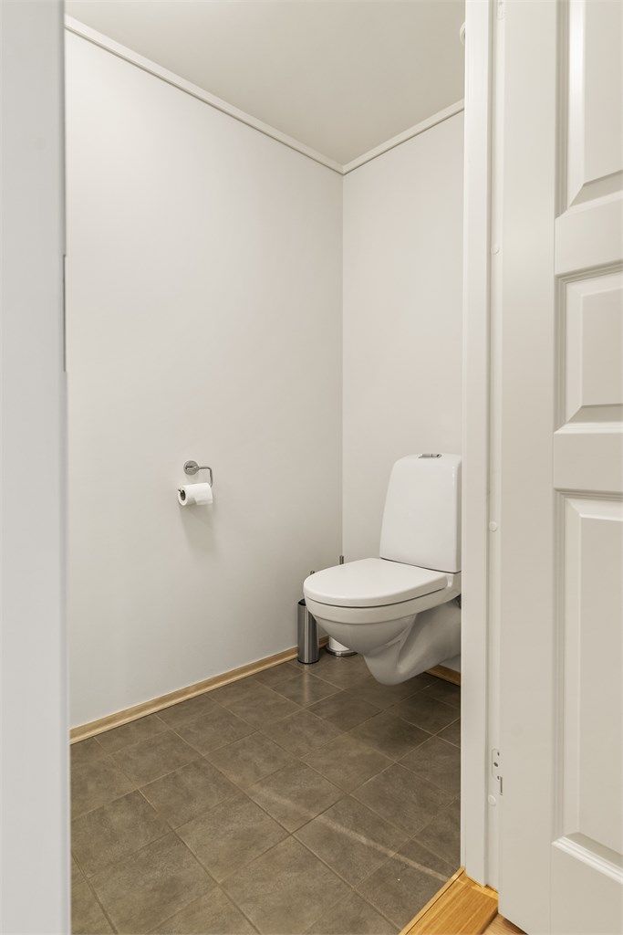 Gjestetoalettet er utstyrt med vegghengt toalett og servant.